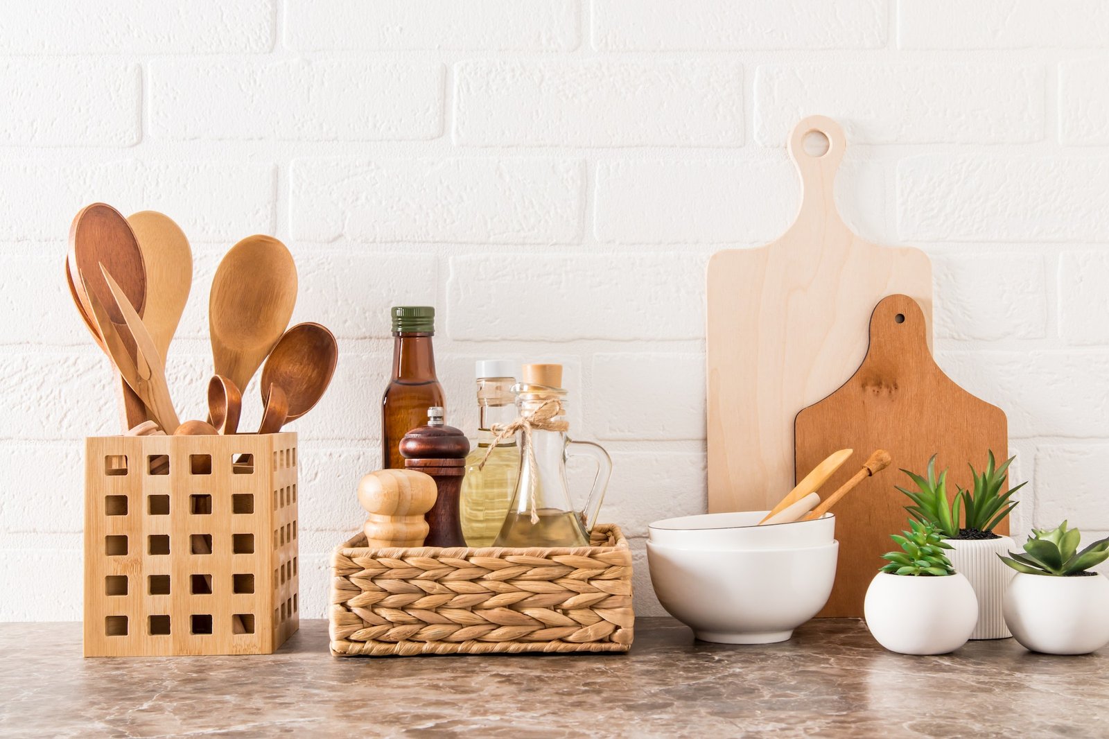 stylish-white-kitchen-background-with-kitchen-utensils-and-green-potted-house-plants-on-a-marble-cou